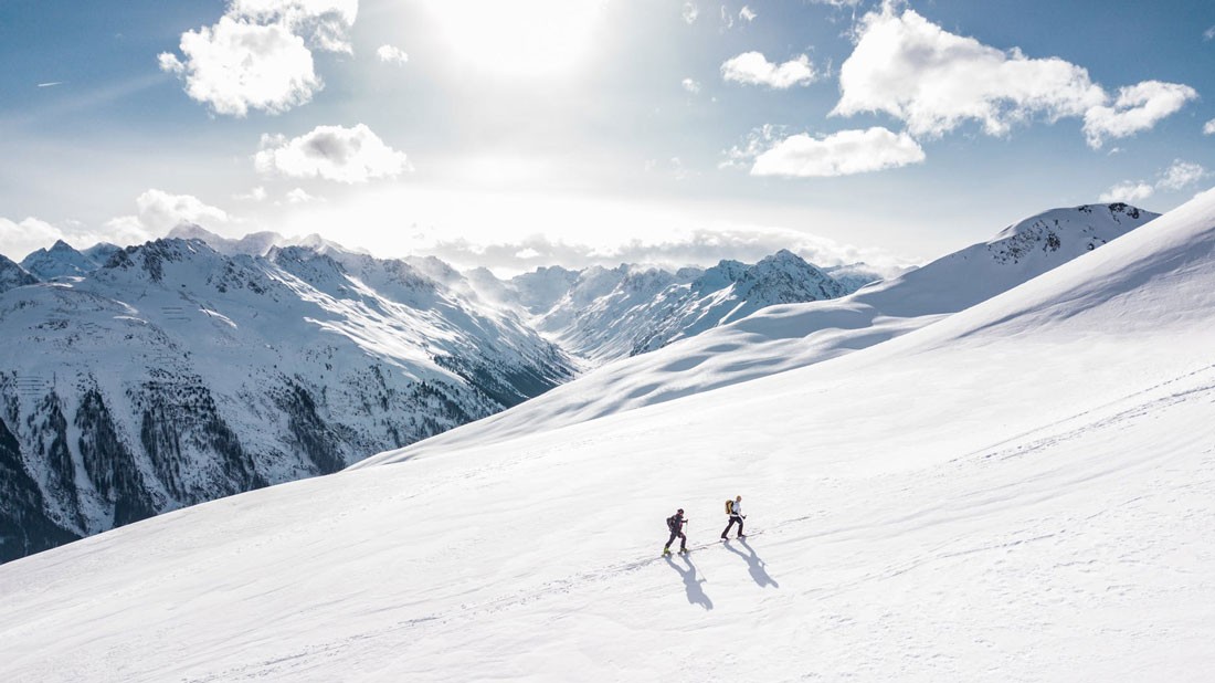 Dos montañeros en las montañas nevadas de Canadá subiendo la montaña